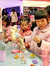 Girls play with Barbie dolls at the Barbie Shanghai flagship store (© Eugene Hoshiko/AP file)