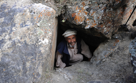 Abdul Karim saliendo de una pequeña cueva-abrigo